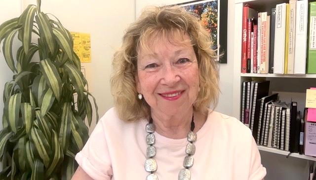 Roz Weitzman, certified ESL tutor and educational consultant, smiling confidently against a vibrant red background symbolizing passion, growth, and communication.